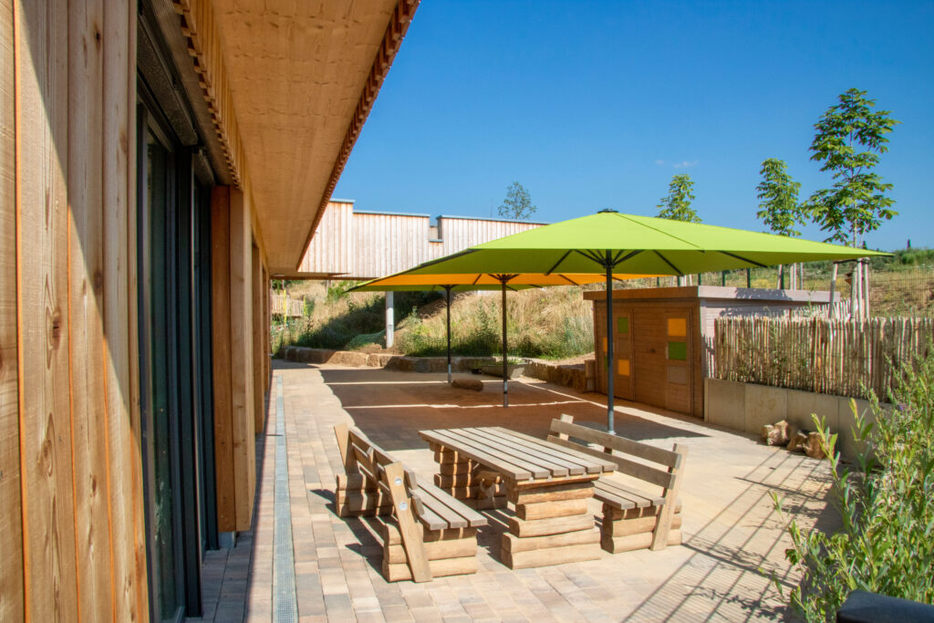 Green and yellow MAY Schattello Parasols shading a wooden decking patio area at a pub