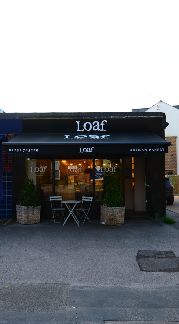 Black branded awning for Loaf bakery in Farnham, sheltering the shop front and al fresco seating area