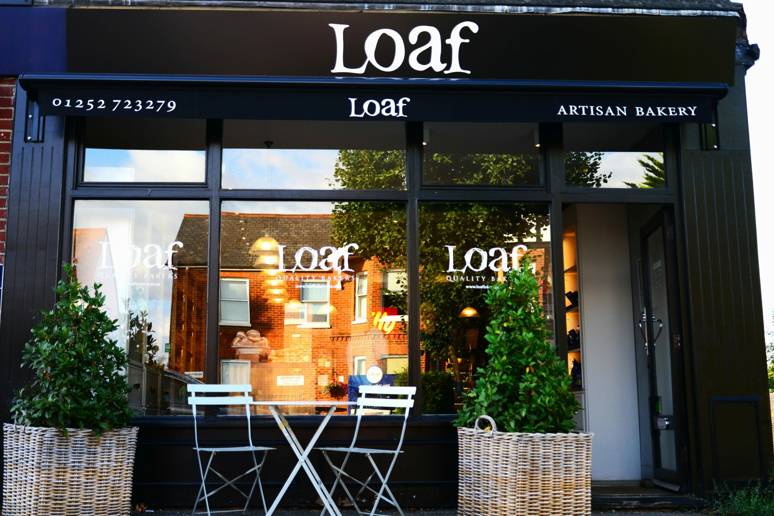 The front of one of Loaf Bakery's Farnham shops with a black branded awning.
